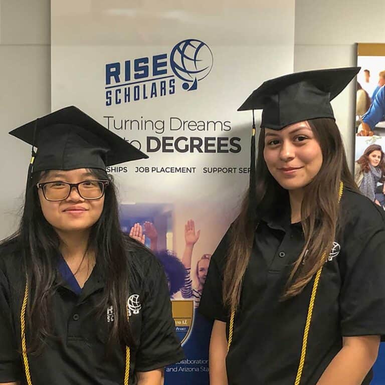 two girls wearing graduation caps in the rise scholars program